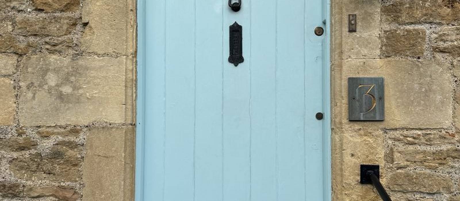 A pale blue front door on a stone cottage