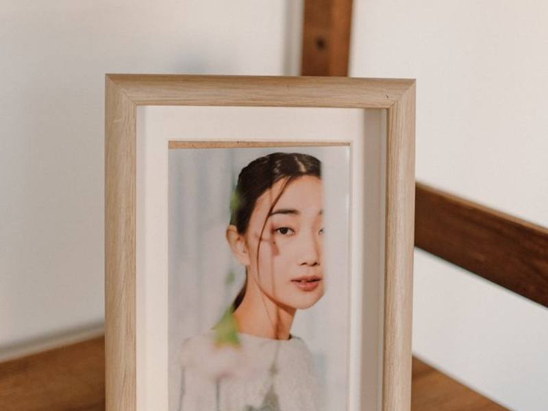 A framed photograph standing on a wooden sideboard